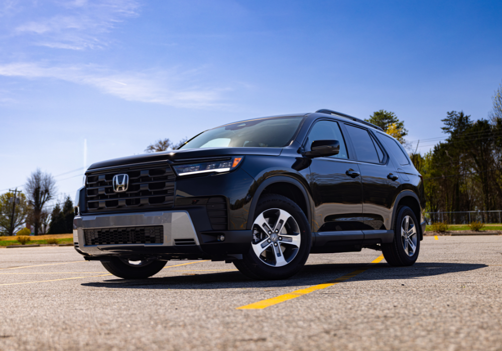 Close up photo of the front half of a new 2025 Honda Pilot. The Honda logo is visible on the front grille.