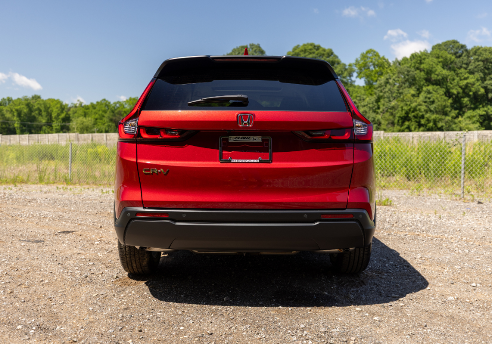 Stock photo of a red 2025 Nissan Rogue for sale. The photo shows the rear exterior of the car